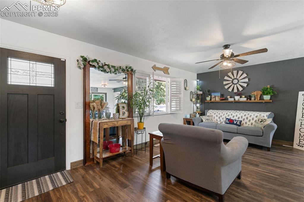 Image 5 of 45: Living area featuring dark wood finished floors and a ceiling fan