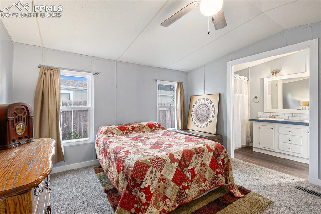 Image 13 of 18: Bedroom with multiple windows, ceiling fan, and carpet flooring