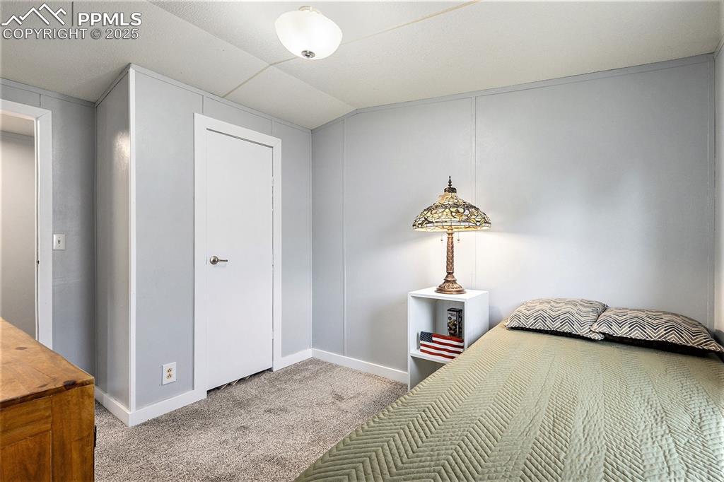 Image 17 of 18: Bedroom with light colored carpet, lofted ceiling, and a closet
