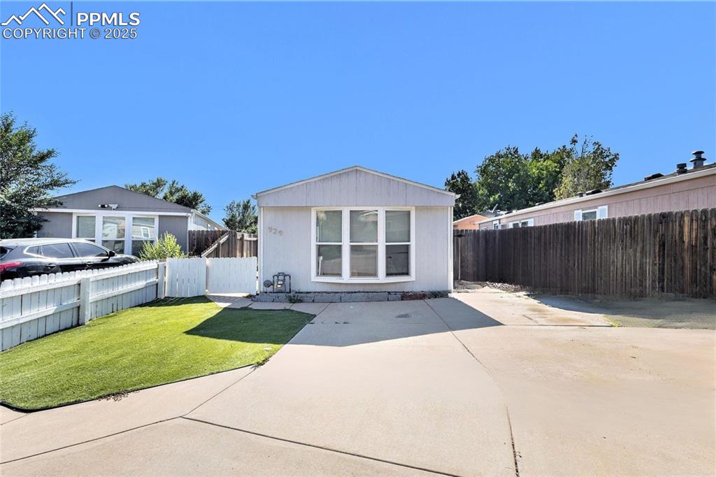 Image 2 of 18: Front of House with a driveway and fenced yard