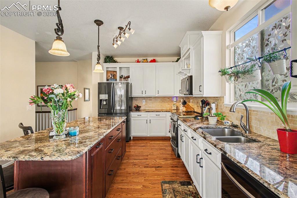 Image 10 of 42: Dual tone kitchen featuring a breakfast bar, stainless steel appliances, tw