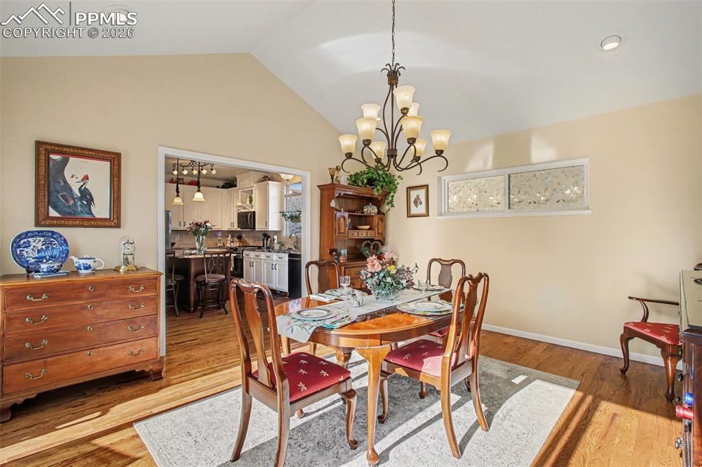 Image 14 of 42: Dining room with lofted ceiling, light wood-type flooring, and hanging ligh