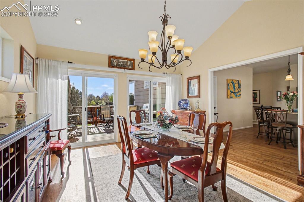 Image 15 of 42: Dining space with light wood-style flooring, lofted ceiling, and hanging li