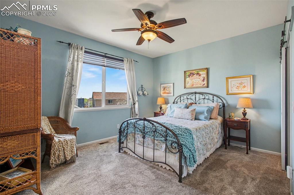 Image 17 of 42: Bedroom with ceiling fan and carpet floors