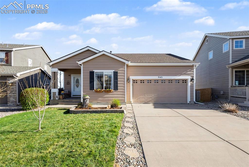 Image 2 of 42: View of front of house with driveway, a front yard, and a garage