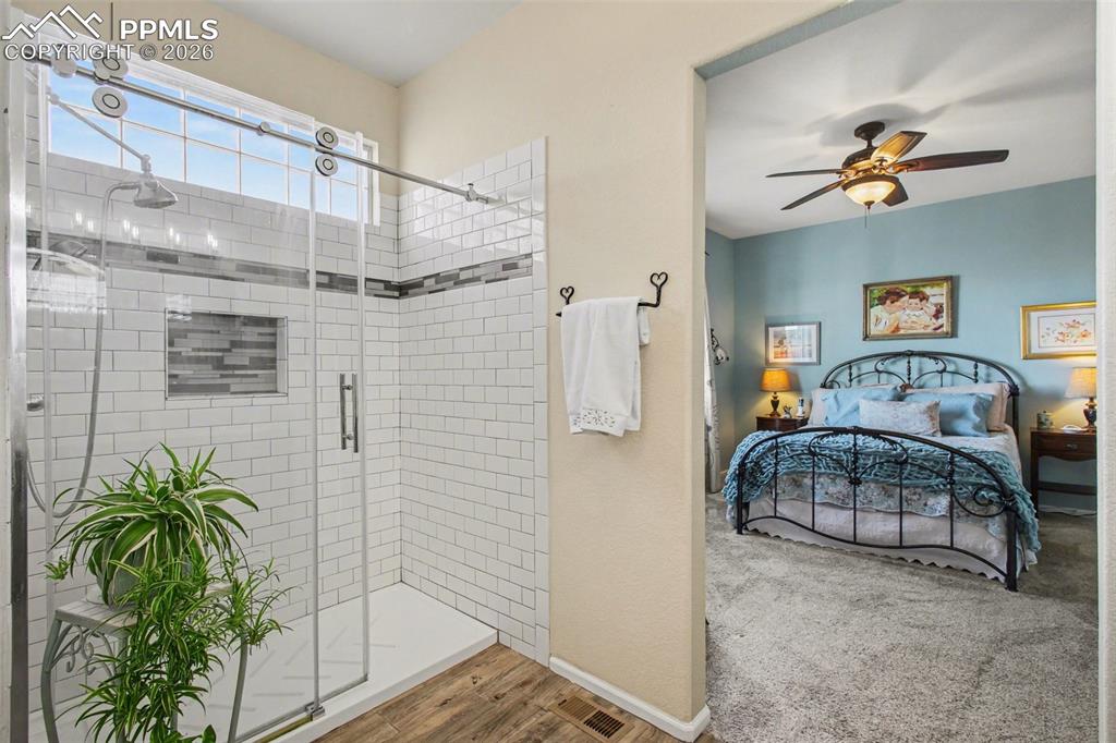 Image 20 of 42: Bathroom featuring ensuite bathroom, a shower stall, a ceiling fan, wood fi