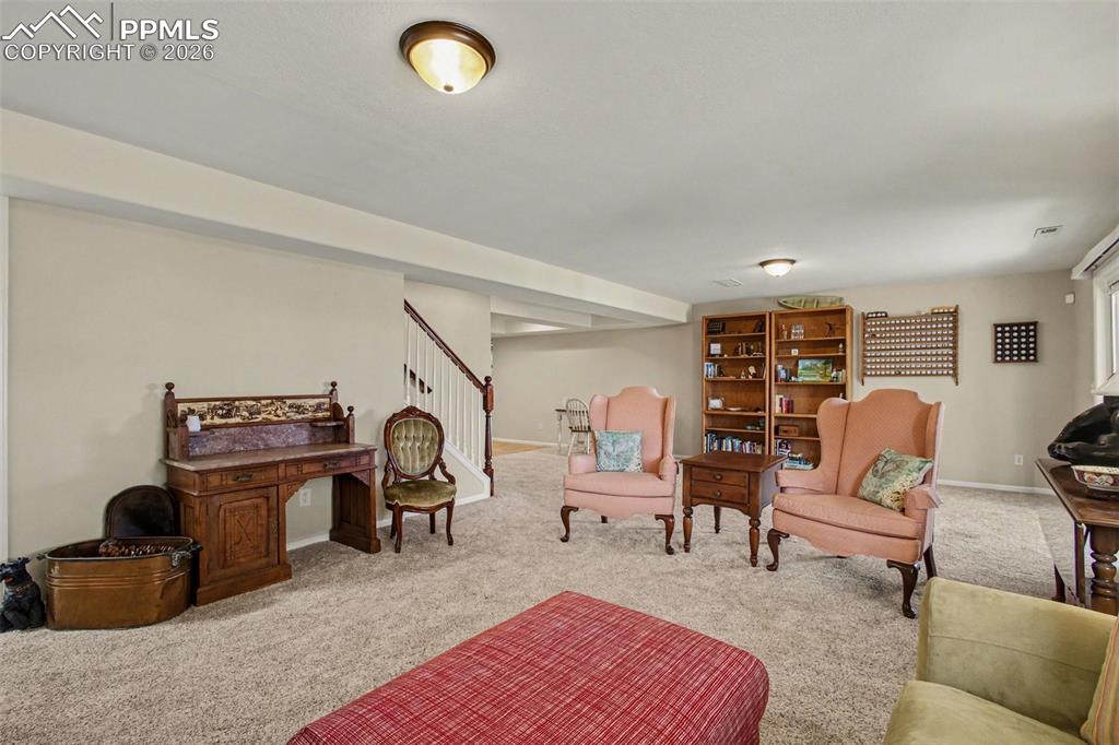 Image 29 of 42: Sitting room with stairway and carpet