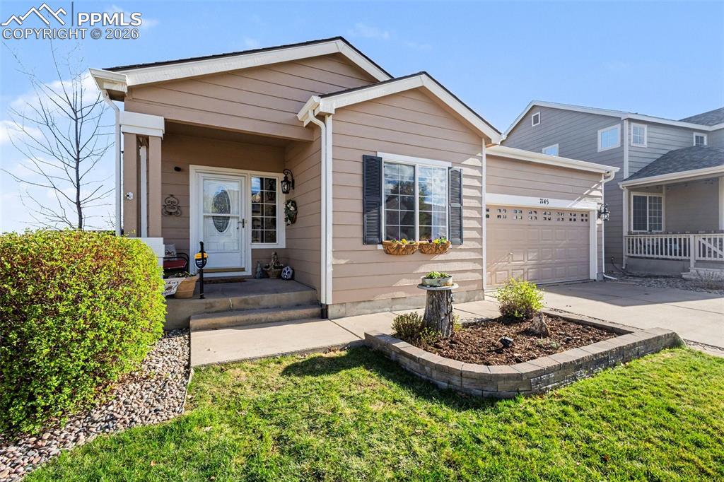 Image 3 of 42: View of front of home with concrete driveway, a garage, and a front yard
