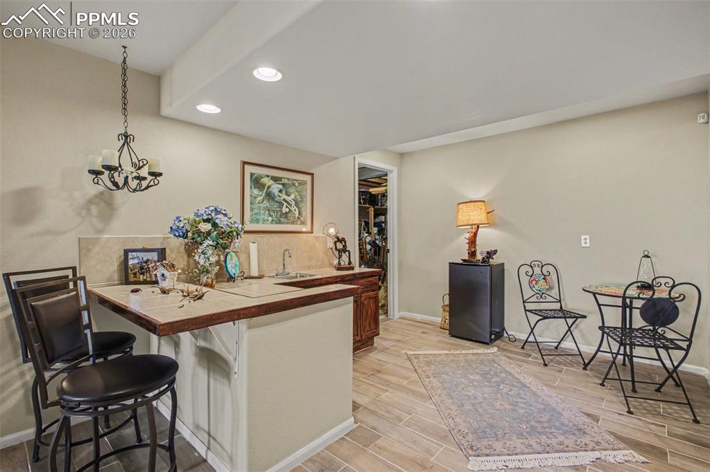Image 30 of 42: Kitchen with a peninsula, a breakfast bar area, wood tiled floors, tile cou