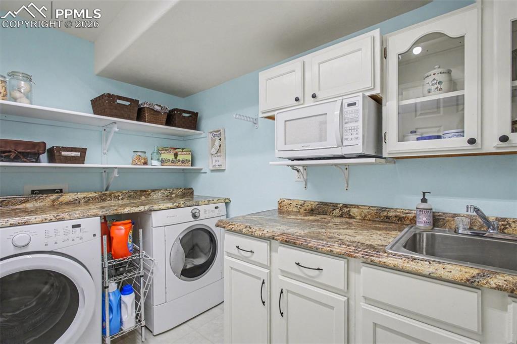Image 32 of 42: Laundry area with washer and dryer and a sink