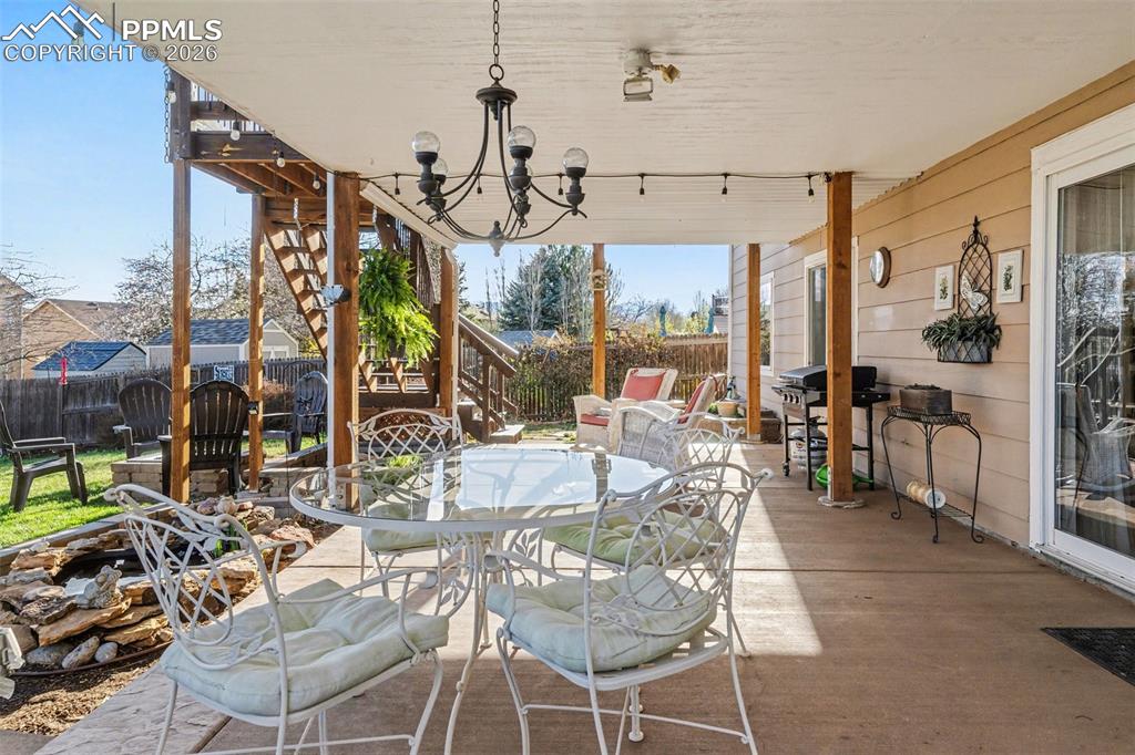 Image 36 of 42: Fenced backyard featuring a patio area, grilling area, and outdoor dining a