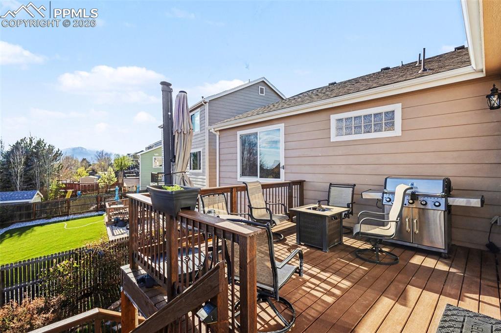 Image 37 of 42: Deck featuring a fire pit, area for grilling, and a playground