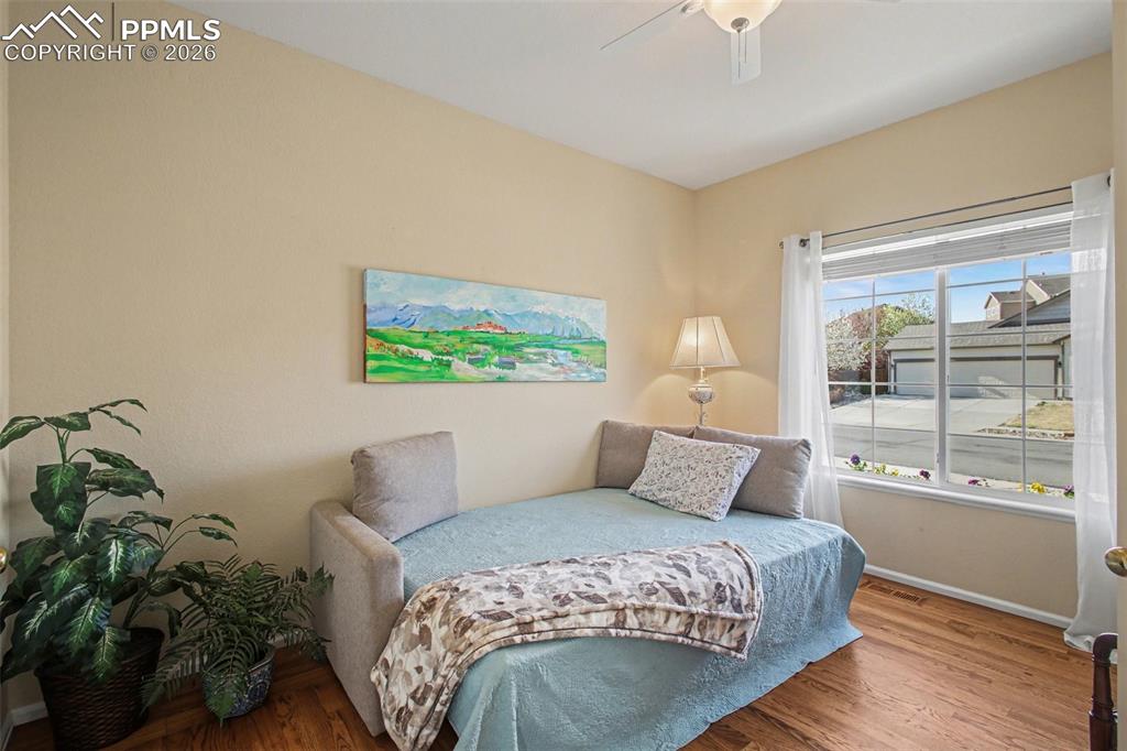 Image 6 of 42: Bedroom with wood finished floors and a ceiling fan