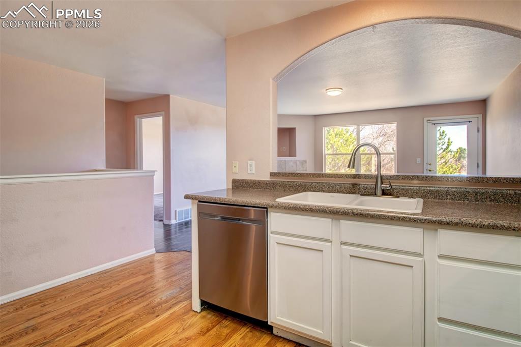 Image 5 of 33: Kitchen with wood floors, stainless steel appliances and ample cabinet spac
