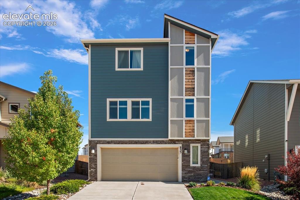 Image 1 of 31: Modern architectural design with a sloped roofline, horizontal siding, ston