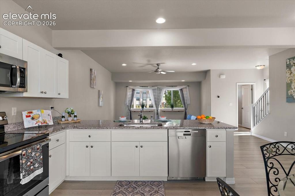 Image 11 of 31: Kitchen featuring white shaker-style cabinetry, stainless steel appliances,