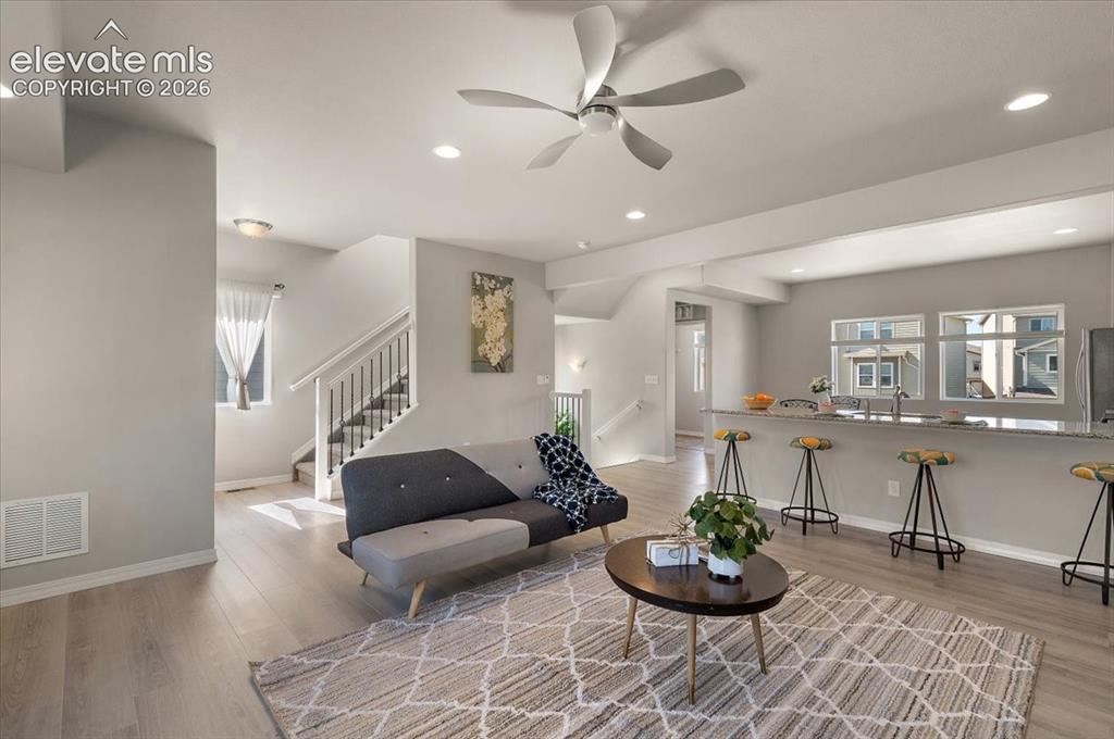 Image 14 of 31: Open-concept living space with wood-finish flooring, recessed lighting, and