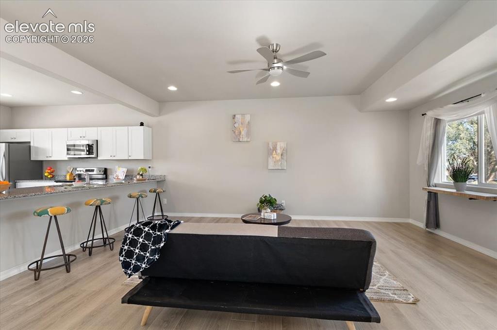 Image 16 of 31: Open-concept living space with wood-finish flooring, recessed lighting, and