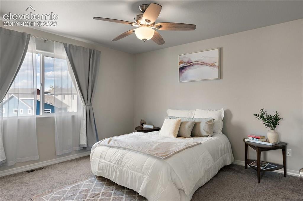 Image 18 of 31: Bright secondary bedroom featuring a ceiling fan with integrated lighting, 