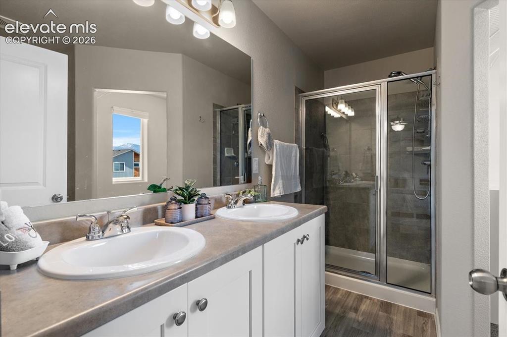 Image 19 of 31: Dual vanity with undermount sinks, chrome fixtures, and white cabinetry