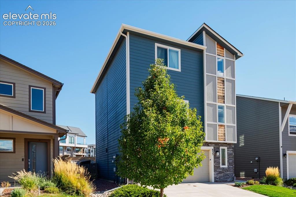 Image 2 of 31: Contemporary exterior featuring blue siding, a multi-story architectural el
