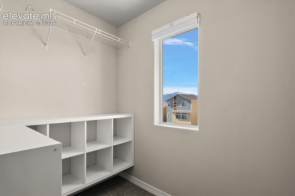 Image 20 of 31: Built-in shelving unit, wire shelving, and a window with a mountain backdro