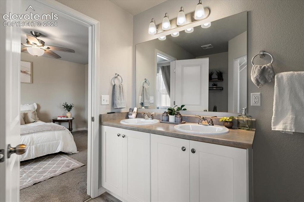 Image 21 of 31: Dual vanity with white cabinetry, polished chrome fixtures, and a large mir