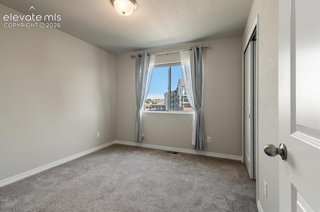 Image 26 of 31: Neutral-toned walls with carpeted flooring, a window with a white frame, an