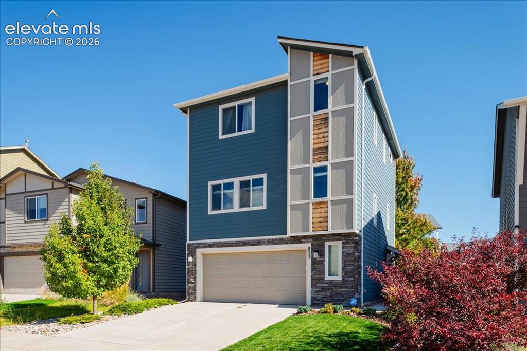 Image 3 of 31: Modern two-story residence featuring a striking blue-gray exterior with mix