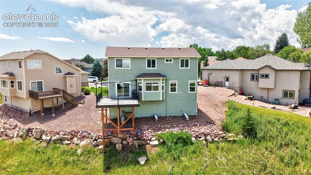 Image 13 of 50: Rear exterior featuring a multi-level deck with black railings, a bay windo