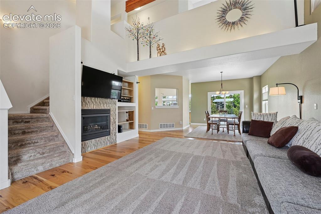 Image 16 of 50: Expansive open-concept interior featuring wood-finish flooring, a contempor