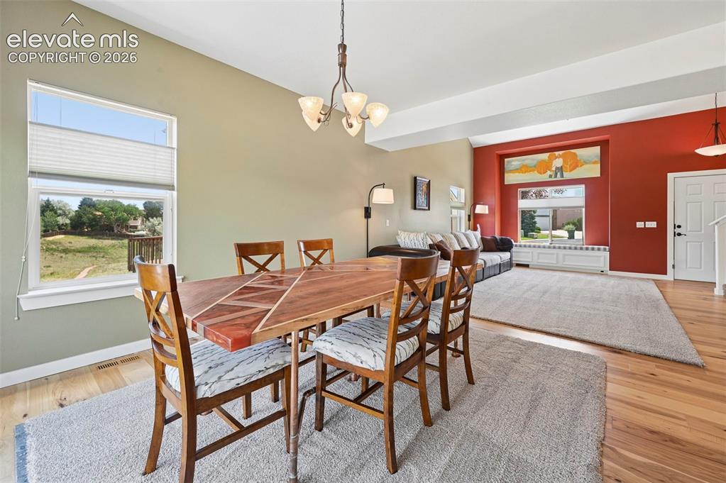 Image 21 of 50: Dining area featuring wood-finish flooring and a contemporary chandelier