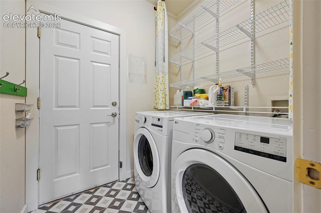 Image 27 of 50: Dedicated laundry area featuring a patterned floor, white paneled door, and
