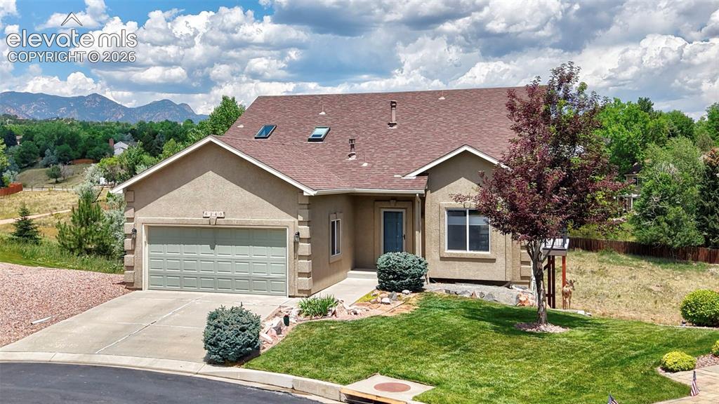 Image 3 of 50: Stucco exterior residence featuring an attached two-car garage with a panel