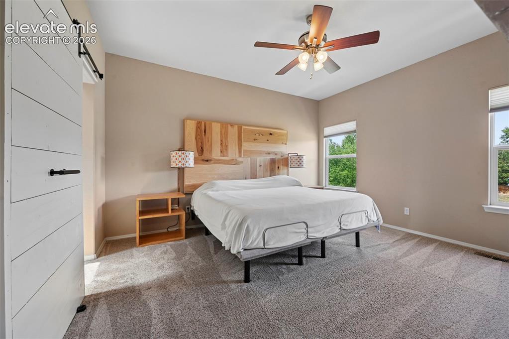 Image 30 of 50: Spacious room featuring vaulted ceilings, a contemporary ceiling fan, dual
