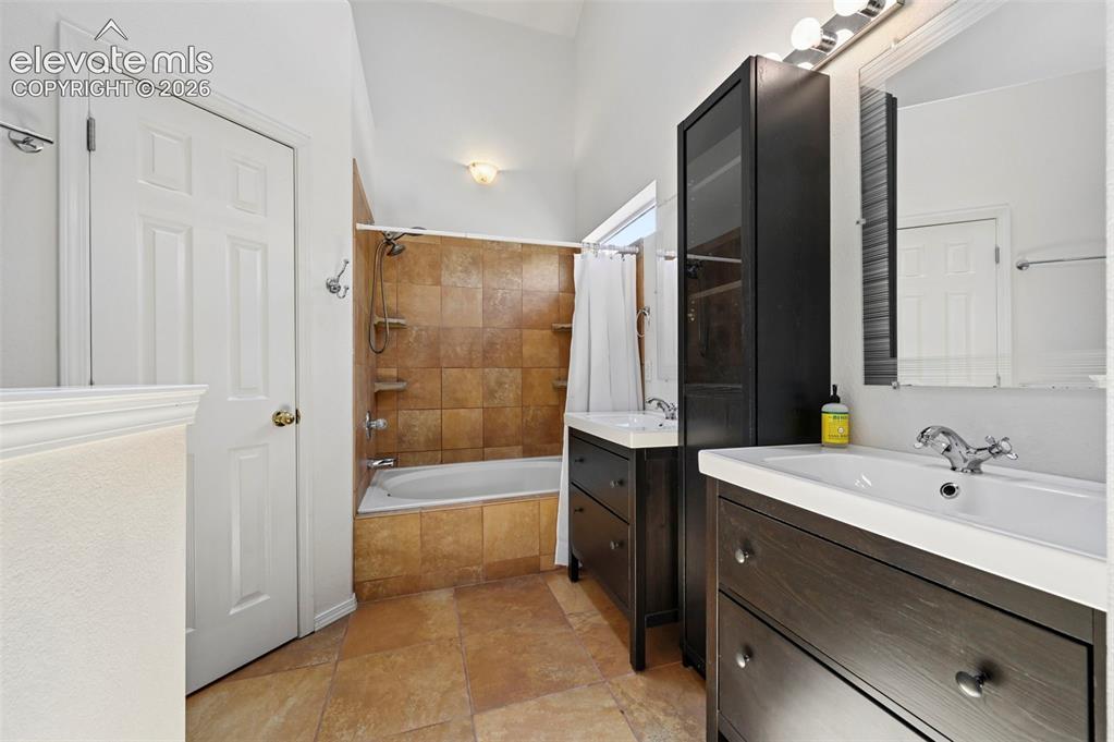 Image 32 of 50: Bathroom featuring dual vanity sinks set in dark wood-finish cabinetry