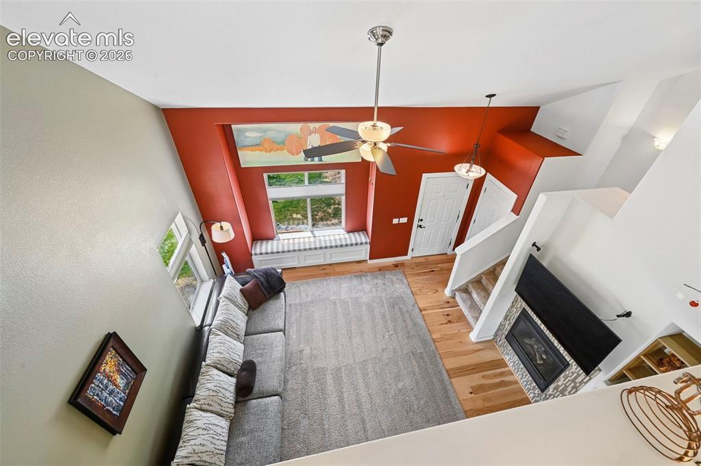 Image 36 of 50: Open-concept living area with high ceilings, wood-finish flooring, a built-