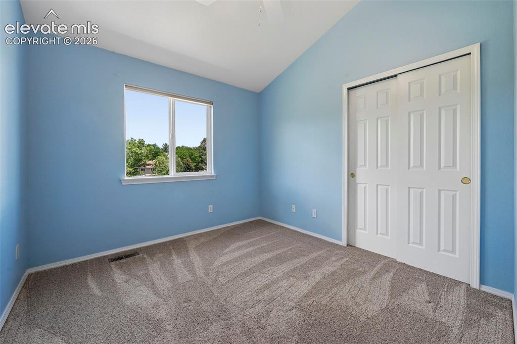 Image 39 of 50: Carpeted room featuring a window with exterior scenery, a white paneled sli