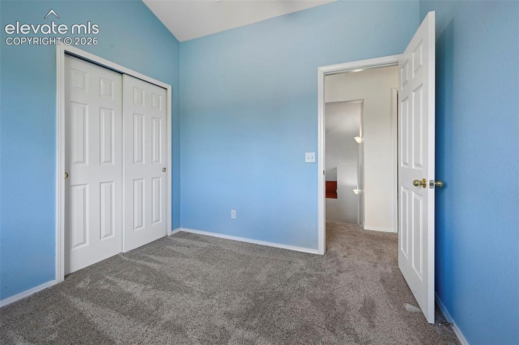Image 40 of 50: Room featuring vaulted ceilings and light blue wall finishes