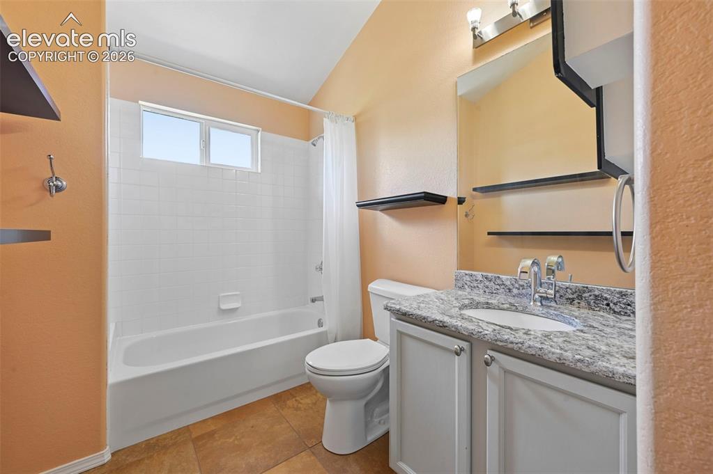 Image 43 of 50: Bathroom featuring a white bathtub with subway tile surround, a vanity with