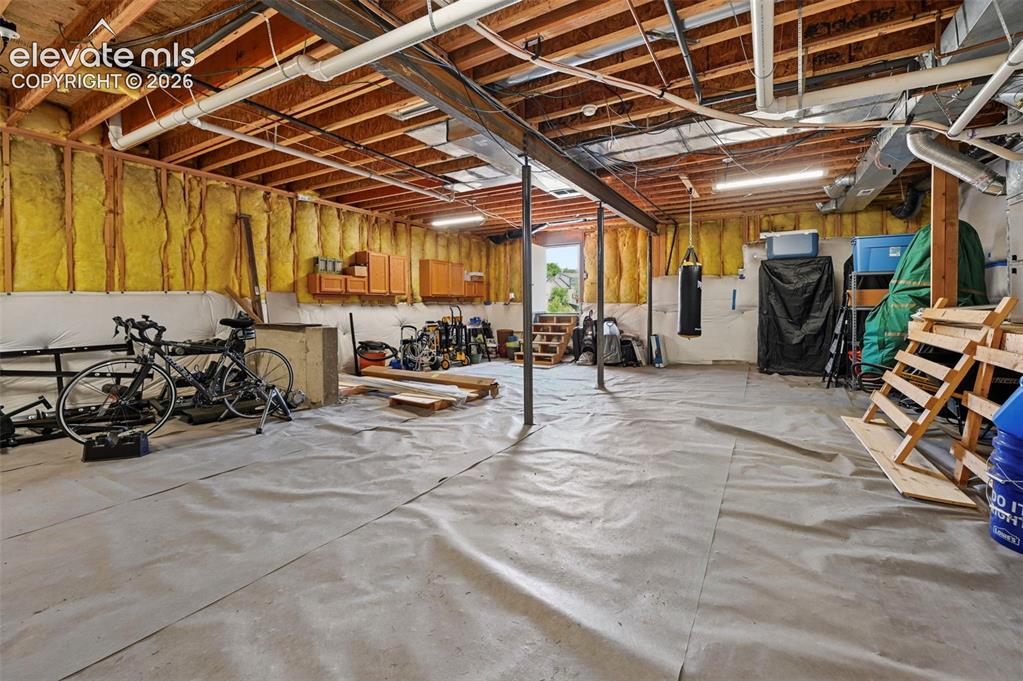 Image 45 of 50: Expansive unfinished basement featuring exposed wood joists and structural