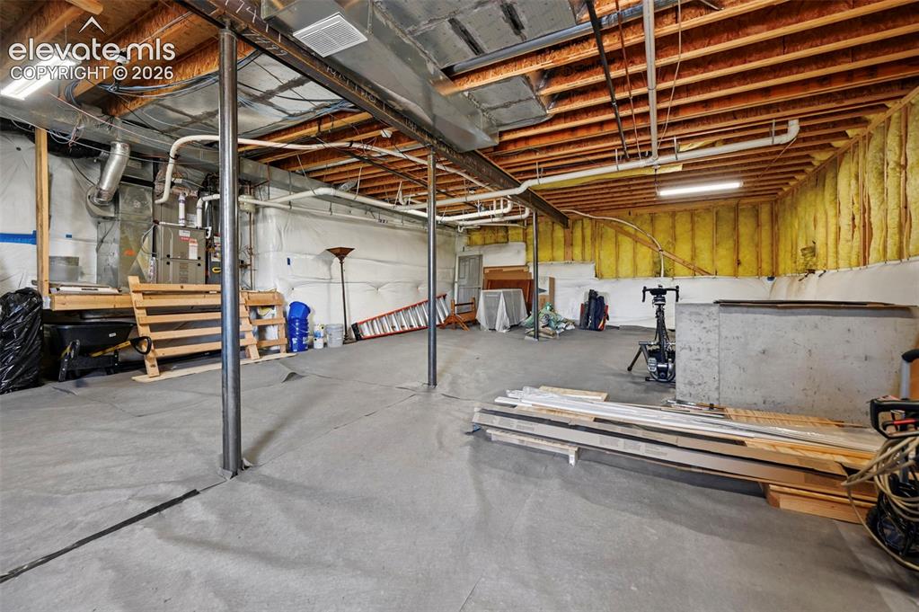 Image 46 of 50: Unfinished basement space featuring a concrete floor, exposed wood ceiling