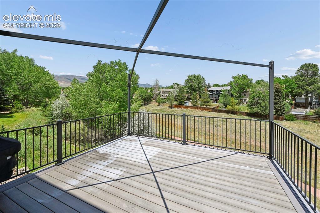 Image 49 of 50: Spacious outdoor deck featuring composite decking, black metal railings, an