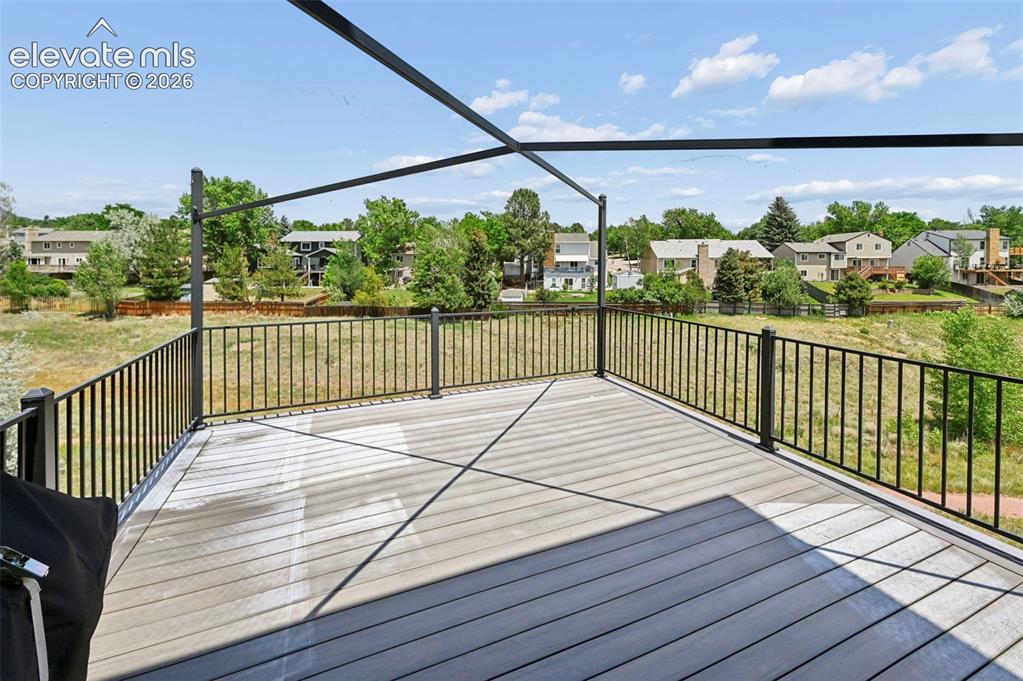 Image 50 of 50: Spacious outdoor deck featuring composite decking, black metal railing, and