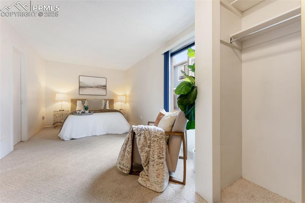 Image 15 of 30: Large primary bedroom with double closets, sitting/dressing area and an ens