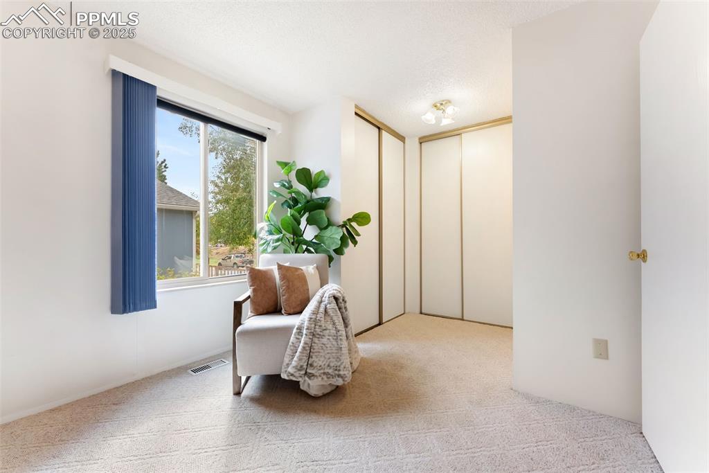 Image 16 of 30: Large primary bedroom with double closets, sitting/dressing area and an ens