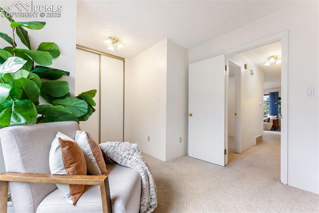 Image 17 of 30: Large primary bedroom with double closets, sitting/dressing area and an ens