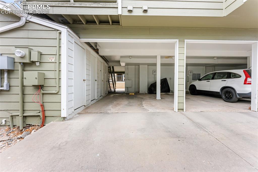 Image 26 of 30: Covered parking attached to the unit with a convenient storage room