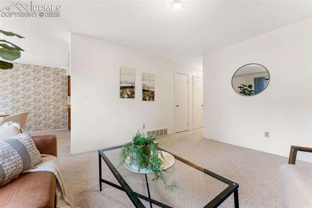 Image 4 of 30: Spacious living room with a wood burning fireplace