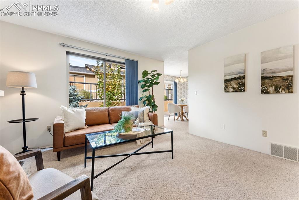 Image 5 of 30: Spacious living room with a wood burning fireplace